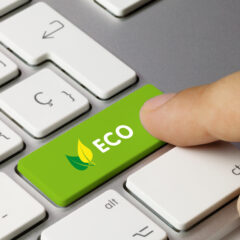 A finger presses a green keyboard key labeled "ECO" with a leaf icon, symbolizing environmental awareness, next to white keys including the Ctrl key.